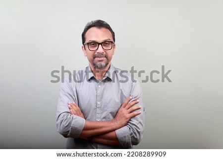 Portrait of a middle aged happy man of Indian origin Royalty-Free Stock Photo #2208289909