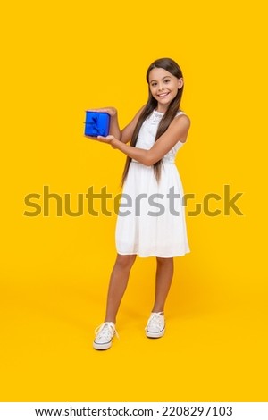 happy teen girl hold present box on yellow background
