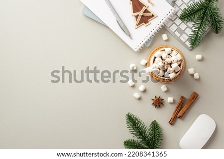 Winter holidays concept. Top view photo of keyboard computer mouse notepads wood christmas tree ornament cup of cocoa with marshmallow pine branches anise cinnamon sticks on isolated grey background