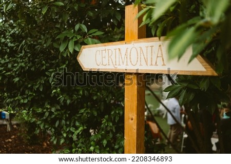 Wooden sign reading "Ceremony" in italian during wedding day celebrations. Detail of wedding decorations