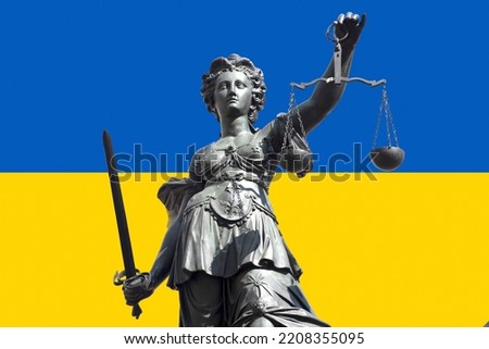 Justice, the symbol of justice with sword and scales in front of the Ukrainian flag. Royalty-Free Stock Photo #2208355095