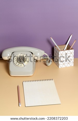 Table with intage office accessories on violet background