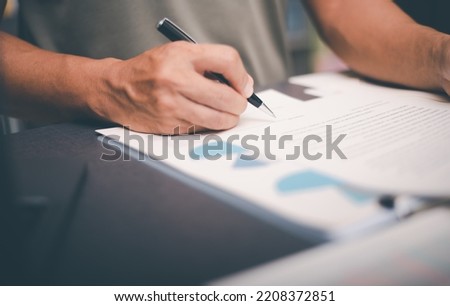 Business owner checking documents and reports and agreements To consider the approval of the business contract, before signing the signature, employment idea, project review, work from home.