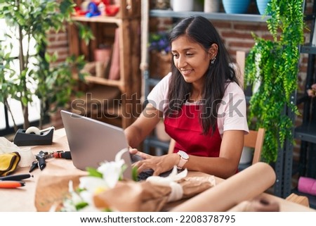 Young beautiful hispanic woman florist smiling confident using laptop at flower shop Royalty-Free Stock Photo #2208378795