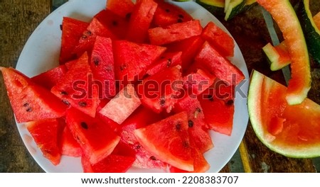watermelon sliced seeded on white plate.