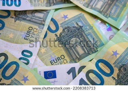 Top view of one hundred euro banknotes. A lot of money is on the table.