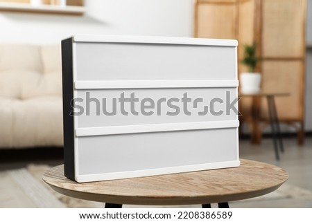 Blank light board on wooden table indoors