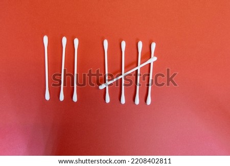 the number eight (8) in Tally marks or hash marks with clean white cotton buds isolated on a dark red background