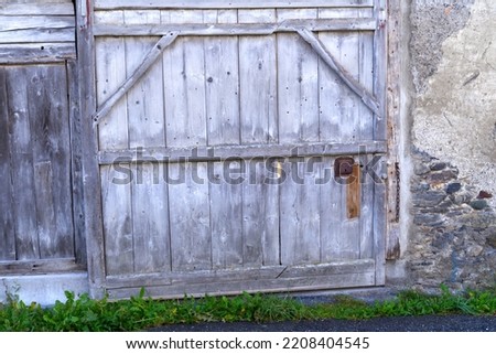 Close-up of weathered wooden gate of agriculture building at mountain village Versam, Canton Graubünden, on a sunny autumn day. Photo taken September 26th, 2022, Versam, Switzerland.