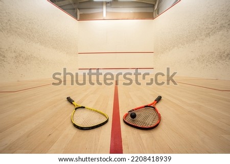 Empty squash court ultra-wide angle view. Racket and ball on the ground, no people. Royalty-Free Stock Photo #2208418939