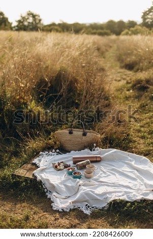 picnic on the grass for two. a white picnic blanket with snacks and two cups of black coffee from a thermos. breakfast picnic with granola and coffee