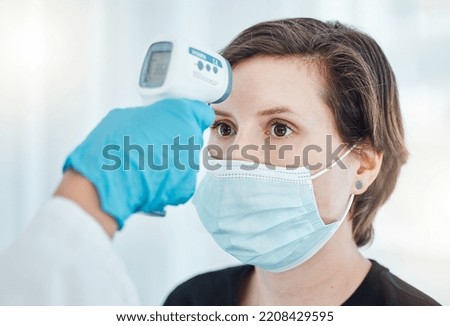 Covid, thermometer and doctor scan fever temperature of woman with mask consulting in hospital. Female patient test for healthcare, safety and protection against coronavirus, illness and virus. Royalty-Free Stock Photo #2208429595