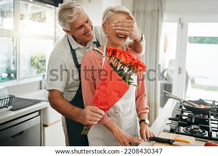Senior couple, covering eyes and flowers surprise as man give wife bouquet of roses on an anniversary, birthday or valentines day in kitchen. Happy old man and woman being romantic in Australia house Royalty-Free Stock Photo #2208430347