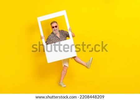 Full body photo of overjoyed carefree person arms hold paper album card isolated on yellow color background