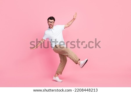 Full length photo of cheerful man dancing wear trendy outfit stand one leg foot good mood empty space isolated on pink color background