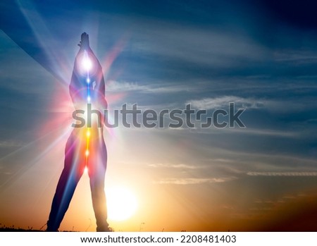 woman in yoga pose on beach sunset view, glowing seven all chakra. Kundalini energy. girl practicing meditation outdoors. Silhouette. Royalty-Free Stock Photo #2208481403