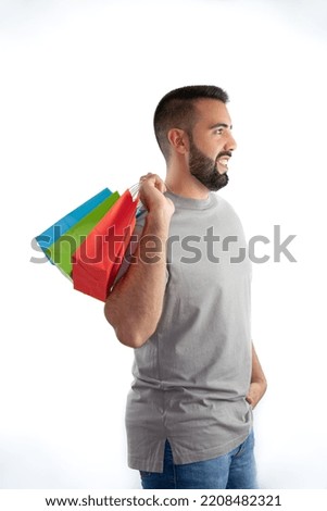 Happy young man holding some colorful bags - concept shopping, black friday, sales, christmas