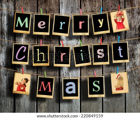 Merry christmas words hanging on clothesline on wood background.