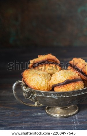Dessert, coconut cookies with dark chocolate in a vintage metal vase on a dark background. Cookie recipes. English cuisine Royalty-Free Stock Photo #2208497645