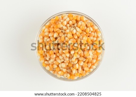 Popcorn in a glass bowl on white background, top view