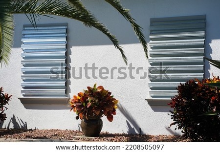 Home prepares for hurricane by putting up storm shutters.                        Royalty-Free Stock Photo #2208505097