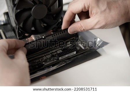 
man's hands installing memory in a PC