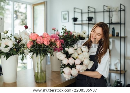 Florist woman in workspace of flower shop. - stock photo