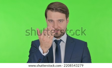 Young Businessman Pointing at Camera, Inviting on Green Background