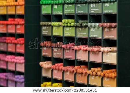 Colorful background with multi-colored pencils placed on rack in art and crafts store. High quality photo