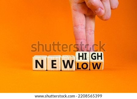 New low or high symbol. Concept words New high and New low on wooden cubes. Businessman hand. Beautiful orange table orange background. Business new low or high concept. Copy space.