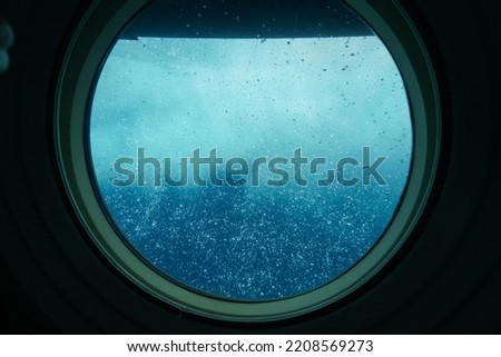 Bubbles visible through the porthole of a submarine surfacing in front of Waikiki Beach in Honolulu, Hawaii Royalty-Free Stock Photo #2208569273