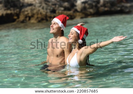 Couple bathing on tropical beach on christmas holidays in a clean transparent sea water
