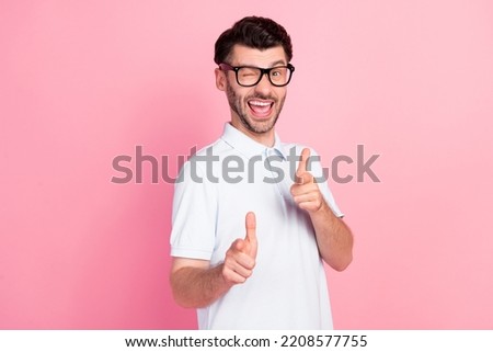 Portrait photo of young attractive handsome man wear glasses showing pointing fingers you flirt blink eye isolated on bright pink color background
