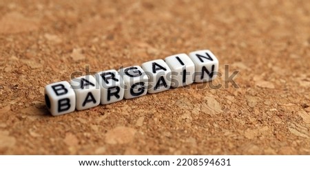Bargain word of plastic cube concept on wooden background.