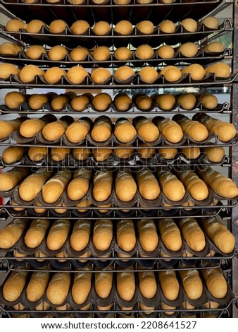 Multiple trays of baguettes fresh out of the oven at a commercial bakery in French Polynesia