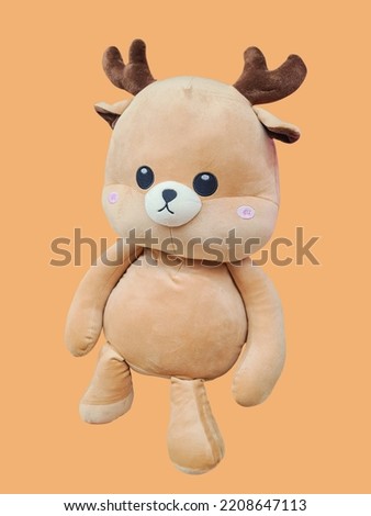 cute brown chubby deer figurine on isolated orange background