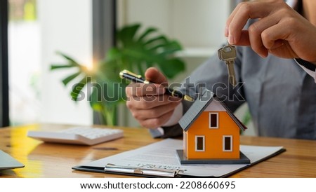 The real estate agent holds the house keys to the customer after the contract is signed. real estate sales ideas