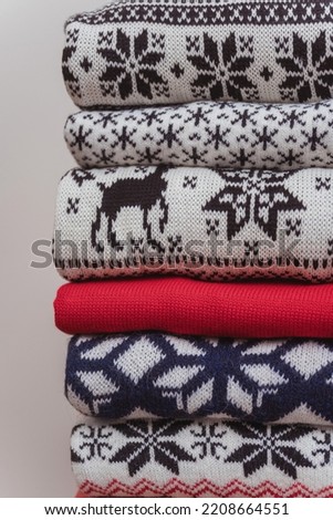 New Year's warm knitted sweaters lying on top of each other. knitted Christmas jumpers with a pattern folded together on a white background.texture of knitted Christmas sweaters