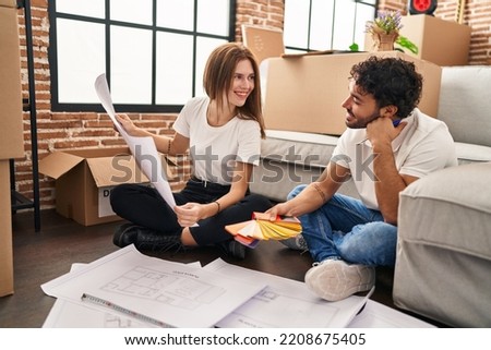 Man and woman couple smiling confident choose paint color at new home