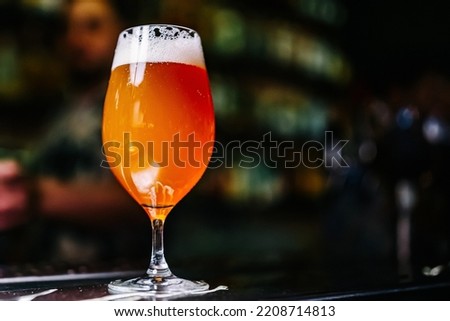 glass of beer stands on bar counter in a bar or pub