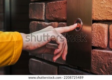 Young woman pressing elevator button