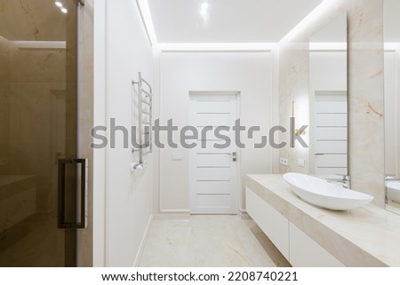 bathroom interior design with light tiles and glass shower