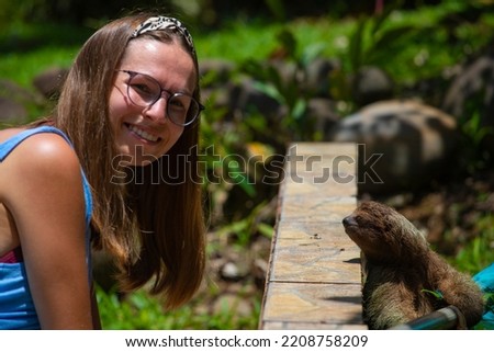 happy girl and her friend the sloth; interaction with the sloth, a visit by a sloth in the garden, wild animals of costa rica