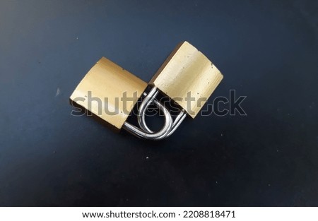 Two gold locks interlocked, on a black background or isolated