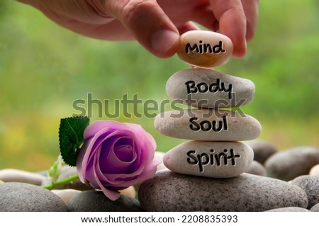 Mind, Body, Soul and Spirit words engraved on zen stones with rose flower. Copy space and zen concept Royalty-Free Stock Photo #2208835393