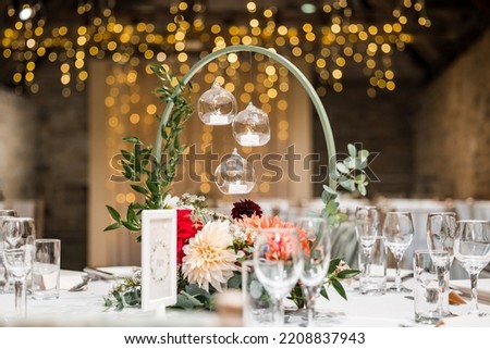 Beautiful candle light wedding table decor with flowers and out of focus twinkle lights. Wedding breakfast party. Royalty-Free Stock Photo #2208837943