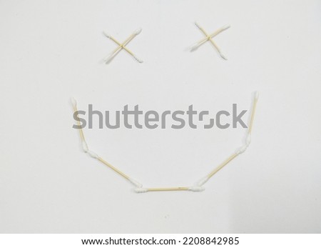 A few ear cotton sticks arranged into a smiley emoji