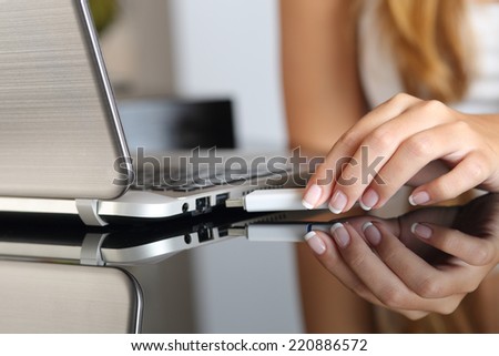 Close up of a woman hand plugging a pendrive on a laptop at home Royalty-Free Stock Photo #220886572