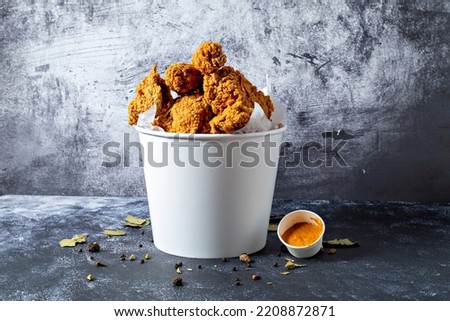 Fried chicken in paper bucket isolated on black background. image Royalty-Free Stock Photo #2208872871