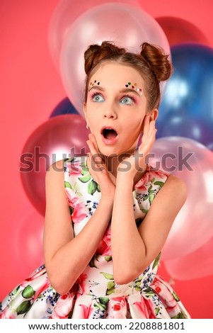 A cute girl with balloons and candy. Pink background. Party.